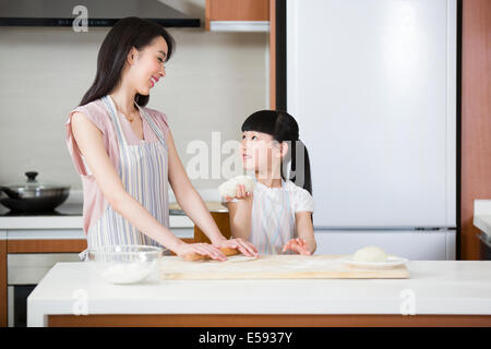 Glückliche Mutter und Tochter Teig ausrollen Stockfoto