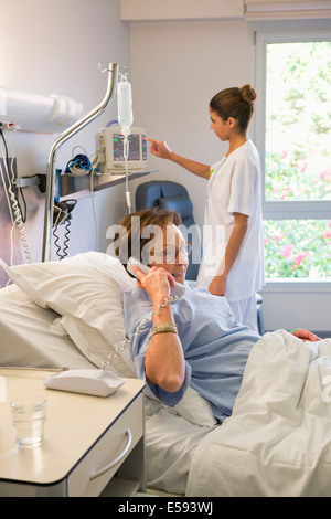 Weibliche Patienten Gespräch am Telefon im Krankenhausbett Stockfoto