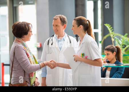 Arzt Händeschütteln mit seinem Patienten im Krankenhaus an der Rezeption Stockfoto