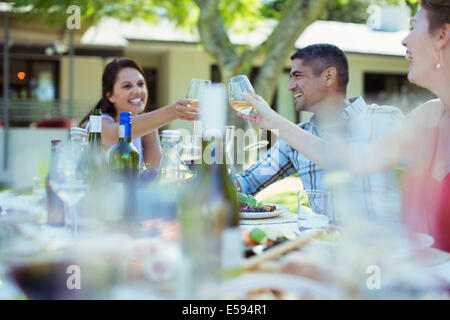 Freunde, toasten einander beim Abendessen im freien Stockfoto
