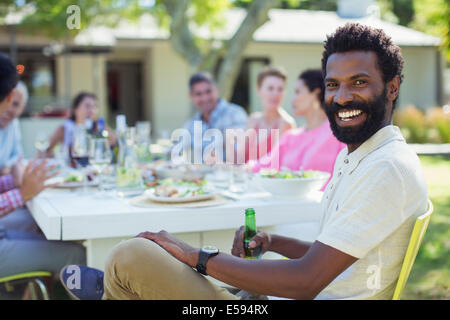 Mann lächelnd am Tisch im freien Stockfoto