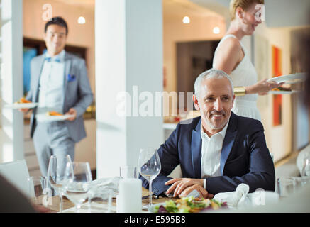 Mann, sitzend am Tisch bei Dinner-party Stockfoto