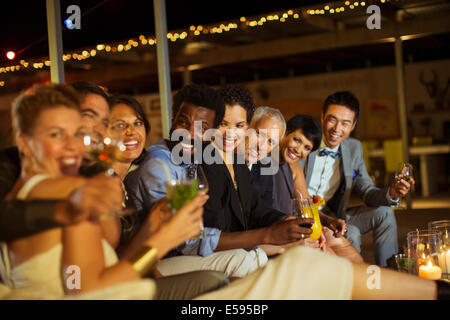 Freunde lächelnd zusammen auf party Stockfoto