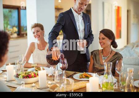 Man gießt Wein bei Dinner-party Stockfoto