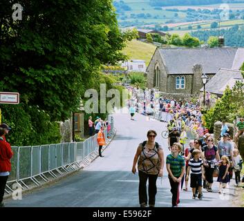 Zuschauer, die zu Fuß zu Aussichtspunkten auf die Strecke der Tour de France durch die Ortschaft hohe Bradfield South Yorkshire England Stockfoto