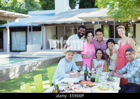 Freunde lächelnd zusammen auf party Stockfoto