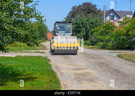 Straßenwalze verdichtet den Kies auf Feldweg Stockfoto