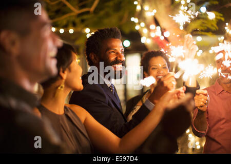 Freunde mit Wunderkerzen auf Party Spielen Stockfoto