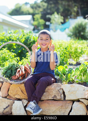 Junge mit Korb von Produkten im Garten Stockfoto