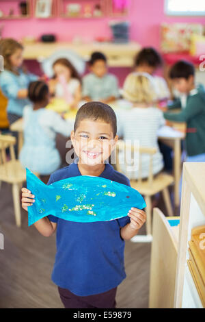 Schüler halten malte Fische im Klassenzimmer Stockfoto