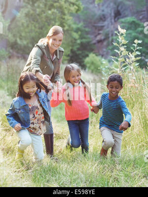 Schüler und Lehrer, die zu Fuß in Feld Stockfoto