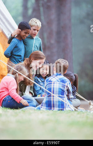 Schüler und Lehrer lesen auf Campingplatz Stockfoto