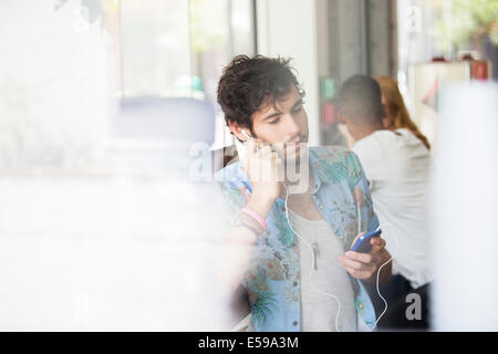 Mann, anhören von MP3-Player im café Stockfoto