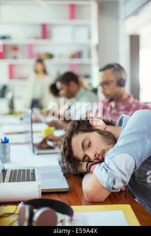 Mann am Schreibtisch im Büro schlafen Stockfoto