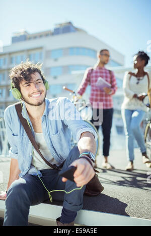 Mann, anhören von MP3-Player auf Stadtstraße Stockfoto
