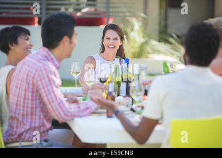 Freunde, die gemeinsam am Tisch im Freien entspannen Stockfoto