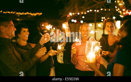 Freunde mit Wunderkerzen auf Party Spielen Stockfoto