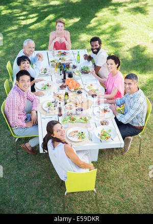 Freunde lächelnd zusammen am Tisch im freien Stockfoto