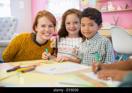 Schüler und Lehrer im Klassenzimmer lächelnd Stockfoto