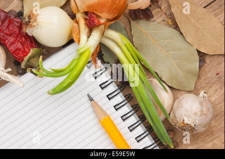 Notebook für Rezepte und Gewürze auf einem alten Holztisch Stockfoto
