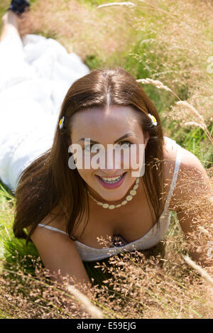 Porträt einer jungen Frau, die Festlegung auf eine Wiese Stockfoto