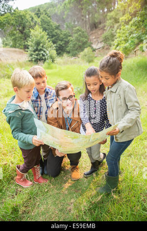 Schüler und Lehrer lesen Karte im Feld Stockfoto