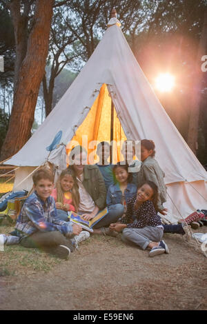 Lehrer und Schüler, die lächelnd auf Campingplatz Stockfoto