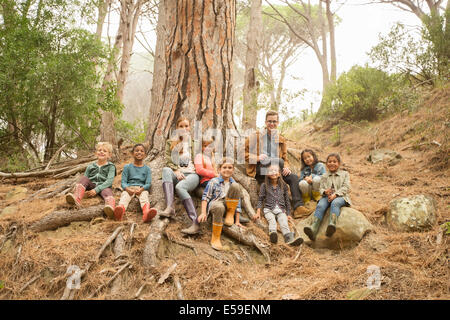 Schüler und Lehrer lächelnd in Wald Stockfoto