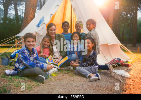 Schüler und Lehrer lächelnd auf Campingplatz Stockfoto