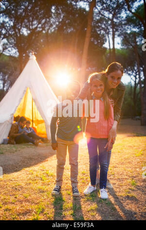 Schüler und Lehrer lächelnd von Tipi auf Campingplatz Stockfoto