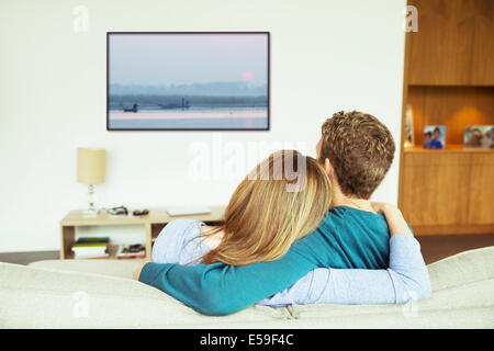 Paar vor dem Fernseher im Wohnzimmer Stockfoto