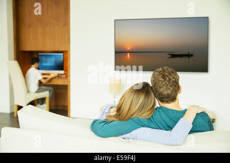 Paar vor dem Fernseher im Wohnzimmer Stockfoto