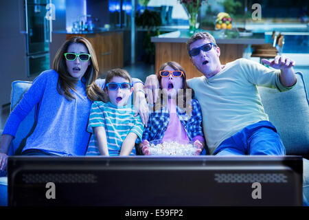 Familie vor dem 3D Fernseher im Wohnzimmer Stockfoto