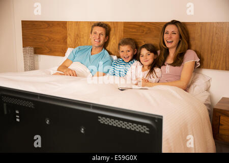 Familie vor dem Fernseher im Bett Stockfoto