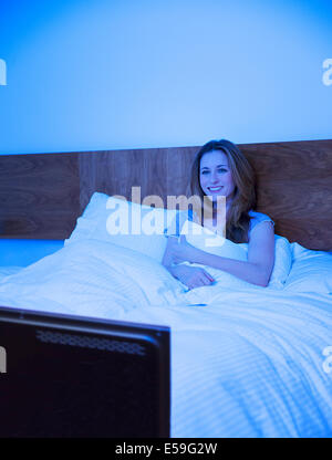 Frau vor dem Fernseher im Bett Stockfoto