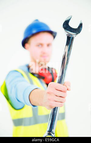 Bau Arbeiter halten große Schraubenschlüssel Stockfoto