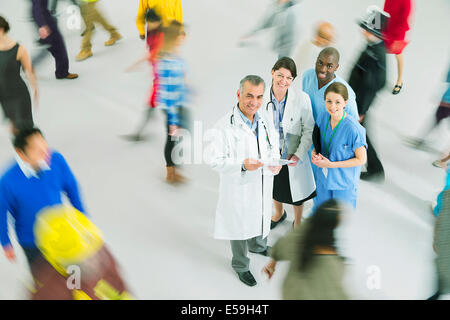 Porträt von zuversichtlich, Ärzten und Krankenschwestern unter Menge Stockfoto