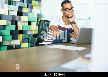 Mann mit Laptop im Büro Stockfoto