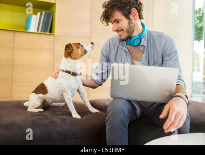 Mann Petting Hund im Büro Stockfoto