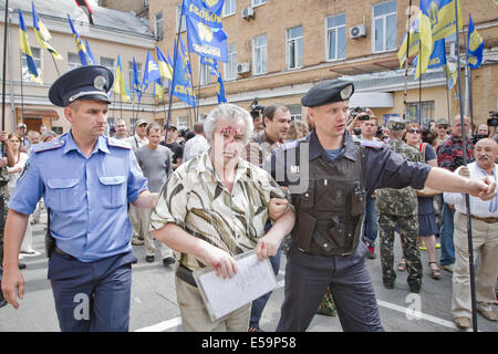 Kiew, Ukraine. 24. Juli 2014. 24. Juli: Polizisten helfen älteren prokommunistische Mann mit Blut im Gesicht, die Website der Nationalisten Rallye in der Nähe von Kiew Verwaltungsgericht zu verlassen, die Anhörung am Verbot der kommunistischen Partei der Ukraine Credit beginnt: Sergii Kharchenko/NurPhoto/ZUMA Draht/Alamy Live News Stockfoto