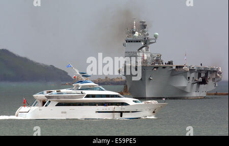 Die neue Yacht, die Zugehörigkeit zu der Aga Khan "Alamshar" Segel vorbei HMS Ocean in Plymouth Sound, Devon, UK Stockfoto