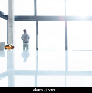 Geschäftsmann am Bürofenster stehen Stockfoto