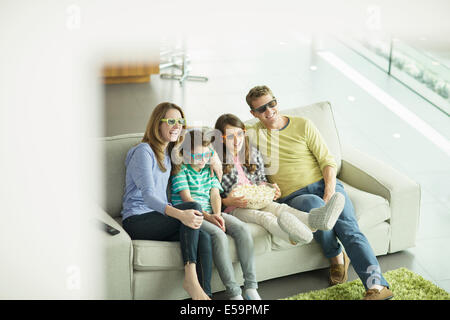 Familie vor dem 3D Fernseher im Wohnzimmer Stockfoto