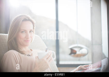 Frau, die Tasse Kaffee auf sofa Stockfoto