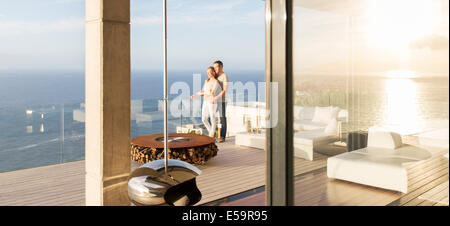 Paar auf modernen Balkon mit Blick auf Meer Stockfoto