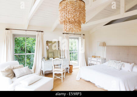 Kronleuchter und Sessel in rustikalen Schlafzimmer Stockfoto