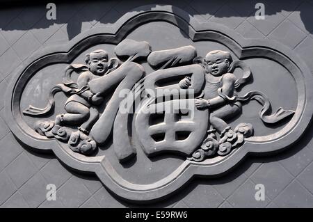 JIE ZI antiken Stadt (SICHUAN), CHINA: Basrelief Figuren halten chinesischen Schriftzeichen auf der Seite eines Gebäudes * Stockfoto