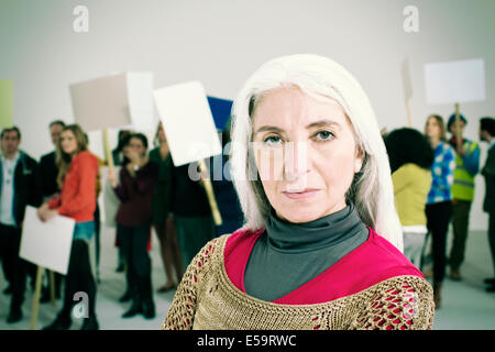 Porträt von Ernst Frau mit Demonstranten im Hintergrund Stockfoto