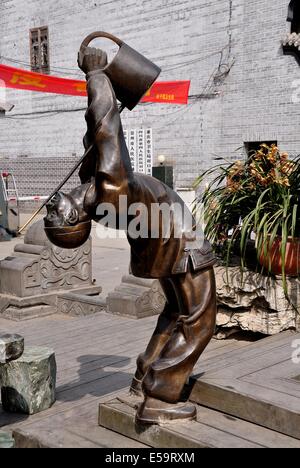 JIE ZI antiken Stadt (SICHUAN), CHINA: Skulptur eines Mannes einen traditionelle Tee Gießen Zeremonie durchführen Stockfoto