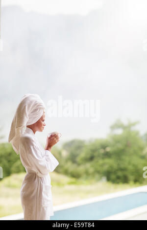Frau im Bademantel Kaffeetrinken im freien Stockfoto
